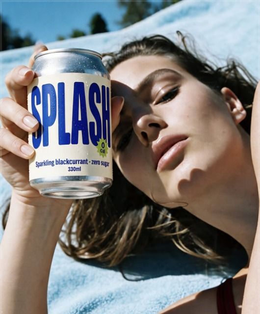 Model with a soda can at the beach